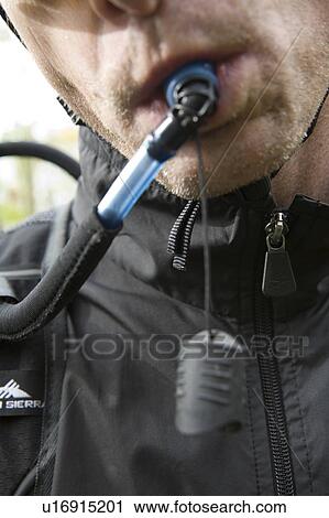 Stock Image - Male cyclist drinking water from water reservoir, Vancouver, BC. Fotosearch