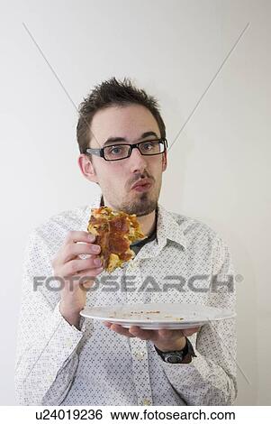 Stock Photograph - Man holding out piece of pizza. Fotosearch