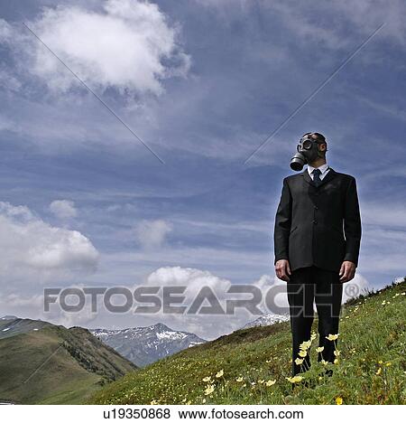 Stock Photo - Man wearing a gas mask and suit in nature. Fotosearch