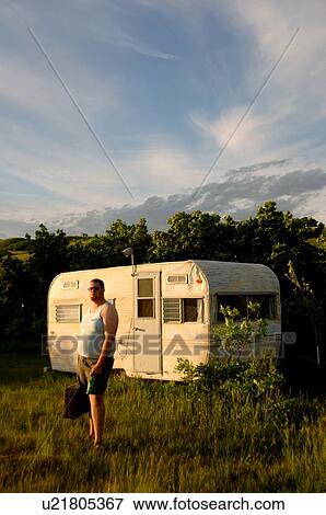 Stock Photo - Man with briefcase stands in front of dumpy trailor; Canada, Saskatchewan, Regina. Fotosearch