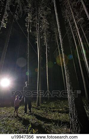 Man with gas mask, hold hands of little girl in eerie trees at night with dramatic back light View Large Photo Image Stock Photograph - Man with gas mask, hold hands of little girl in eerie trees at night with dramatic back light. Fotosearch