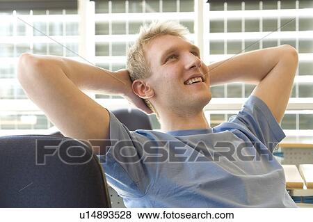 Stock Photo - Portrait of male student in front of solar panelled windows, Winnipeg, Canada.. Fotosearch