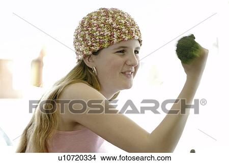 Pre-teen girl holding organic broccoli like a hand weight, wearing shirt made with hemp fibre, Canada, Manitoba, Brandon View Large Photo Image Picture - Pre-teen girl holding organic broccoli like a hand weight, wearing shirt made with hemp fibre, Canada, Manitoba, Brandon. Fotosearch