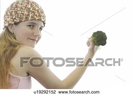 Pre-teen girl holding organic broccoli like a hand weight, wearing shirt made with hemp fibre, Canada, Manitoba, Brandon View Large Photo Image Stock Image - Pre-teen girl holding organic broccoli like a hand weight, wearing shirt made with hemp fibre, Canada, Manitoba, Brandon. Fotosearch