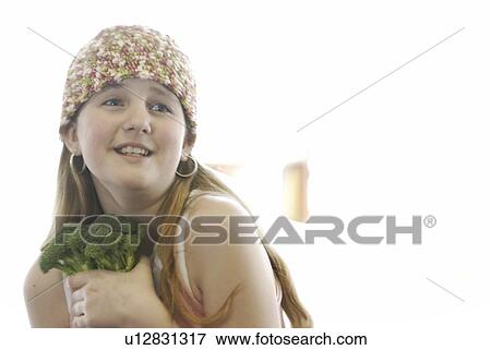 Stock Photo - Pre-teen girl holding organic broccolli, wearing shirt made with hemp fibre, Canada, Manitoba, Brandon. Fotosearch