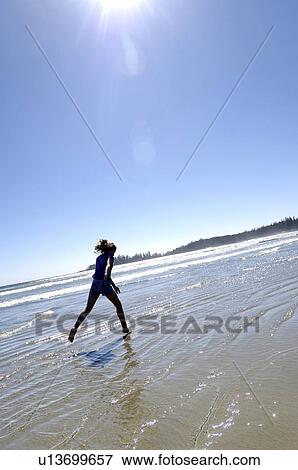 Stock Photo - Pre-teen girl running on beach, Vancouver Island, B. C.. Fotosearch