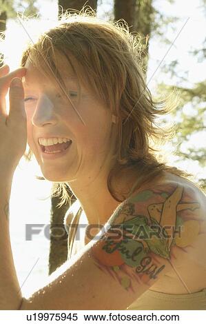 Stock Photography - Profile of woman laughing outdoors, Riding Mountain National Park, Manitoba, Canada. Fotosearch