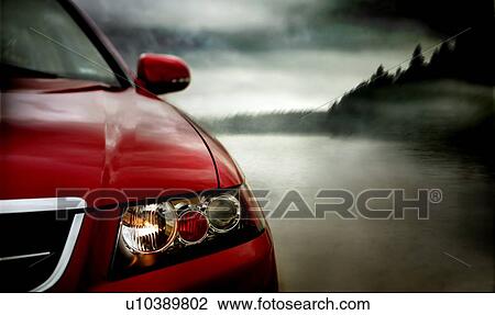 Stock Image - Red car beside lake, Saskatchewan, Canada. Fotosearch