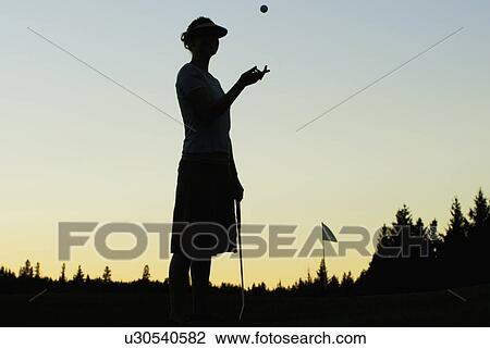 Stock Image - Silhouette of young woman on organic golf course, Clear Lake Golf Course, Riding Mountain National Park, Manitoba, Canada. Fotosearch