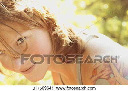 Stock Image - Smiling woman with tattoos, Riding Mountain National Park, Manitoba, Canada. Fotosearch