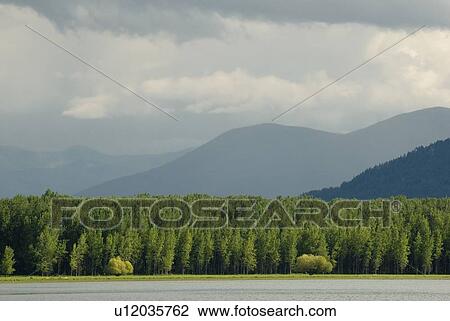 Stock Image - Storm clouds over mountains, Kootenay Lake, Kuskonook, BC, Canada. Fotosearch
