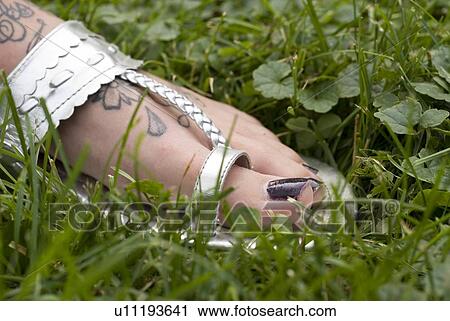 Tattooed foot of woman wearing silver sandal, Munson Park, Winnipeg, Canada View Large Photo Image Stock Image - Tattooed foot of woman wearing silver sandal, Munson Park, Winnipeg, Canada. Fotosearch
