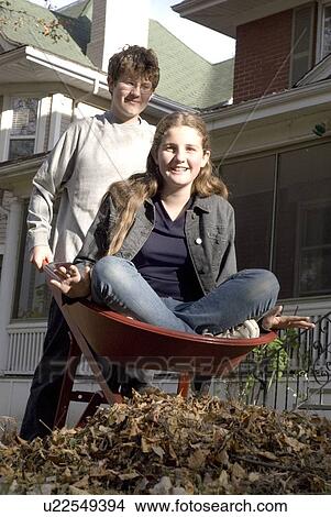 Teen brother carrying sister in wheelbarrow, Winnipeg, Canada View Large Photo Image Picture - Teen brother carrying sister in wheelbarrow, Winnipeg, Canada. Fotosearch