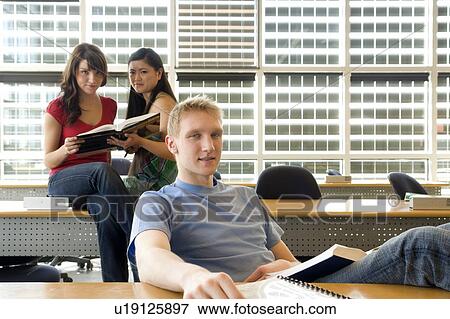 Two female students in background, male in foreground, in front of solar panelled windows, Winnipeg, Canada View Large Photo Image Stock Photo - Two female students in background, male in foreground, in front of solar panelled windows, Winnipeg, Canada. Fotosearch