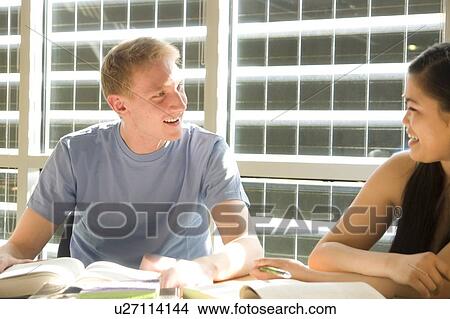 Two students seated, talking, in front of solar panelled windows, Winnipeg, Canada View Large Photo Image Picture - Two students seated, talking, in front of solar panelled windows, Winnipeg, Canada. Fotosearch