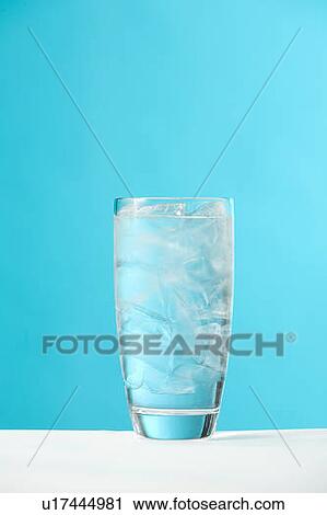 Stock Image - Very full glass of water with ice. Fotosearch