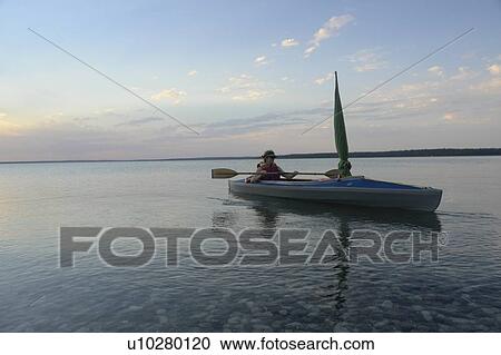 Stock Image - Woman in kayak Clear Lake Riding Mt. Nat. Park; Canada, Manitoba, Riding Mountain National Park. Fotosearch