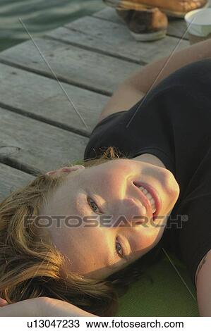 Woman lying on dock by lake, Clear Lake, Riding Mountain National Park, Manitoba, Canada View Large Photo Image Stock Image - Woman lying on dock by lake, Clear Lake, Riding Mountain National Park, Manitoba, Canada. Fotosearch