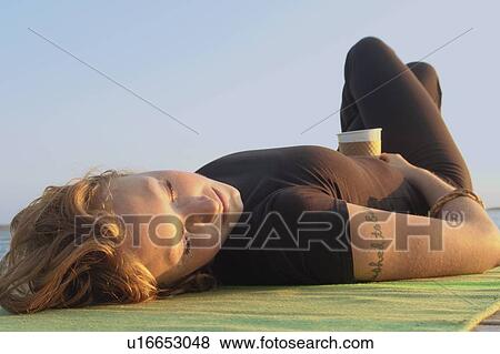 Woman lying on dock by lake, Clear Lake, Riding Mountain National Park, Manitoba, Canada View Large Photo Image Stock Photo - Woman lying on dock by lake, Clear Lake, Riding Mountain National Park, Manitoba, Canada. Fotosearch