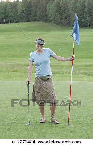 Picture - Woman on putting green, wearing hemp shirt, organic golf course, Clear Lake Golf Course, Riding Mountain National Park, Manitoba, Canada. Fotosearch