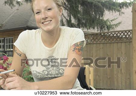Woman seated at outdoor restaurant, holding pen, Wasagaming, Riding Mountain National Park, Manitoba, Canada View Large Photo Image Stock Image - Woman seated at outdoor restaurant, holding pen, Wasagaming, Riding Mountain National Park, Manitoba, Canada. Fotosearch
