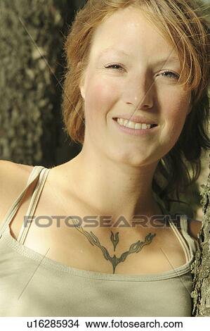 Woman smiling, in front of tree, Riding Mountain National Park, Manitoba, Canada View Large Photo Image Picture - Woman smiling, in front of tree, Riding Mountain National Park, Manitoba, Canada. Fotosearch