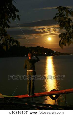Woman views moon over Echo Lake, Saskatchewan, Canada View Large Photo Image Stock Photo - Woman views moon over Echo Lake, Saskatchewan, Canada. Fotosearch