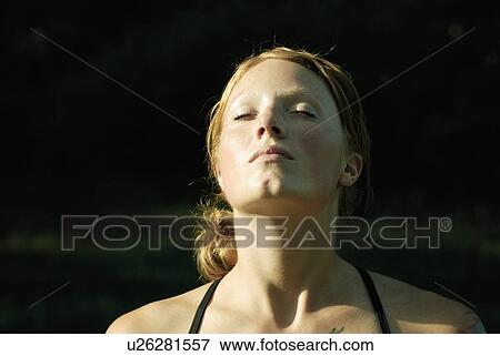 Stock Photo - Woman with eyes closed and head tilted up, Grayling Lake, Riding Mountain National Park, Manitoba, Canada. Fotosearch