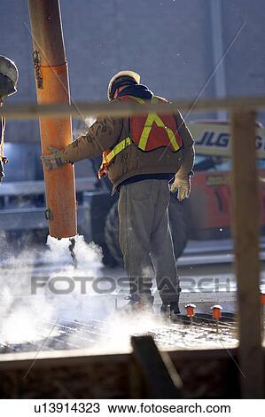 Stock Image - Workers pouring cement into rebar form; Canada, Ontario, Hamilton (Composting Facility). Fotosearch