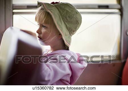 Stock Image - Young girl wearing sun hat riding passenger bus, Cypress Hills, Saskatchewan. Fotosearch