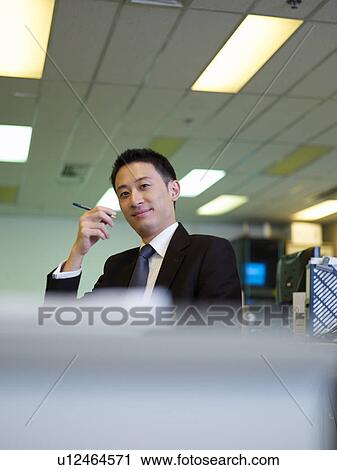 Businessman sitting in chair and holding a Pen View Large Photo Image Stock Image - Businessman sitting in chair and holding a Pen. Fotosearch