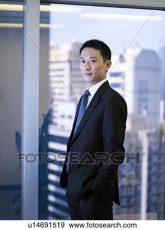 Stock Photo - Businessman standing by window. Fotosearch