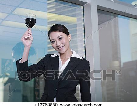Businesswoman holding glass of wine View Large Photo Image Stock Image - Businesswoman holding glass of wine. Fotosearch