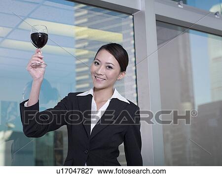 Stock Photo - Businesswoman holding glass of wine. Fotosearch