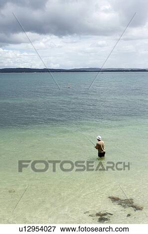 Stock Photo - Man fishing in the beach. Fotosearch