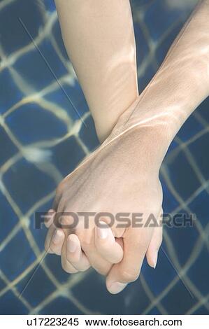 Stock Photography - Couple holding hands in swimming pool, Saipan. Fotosearch