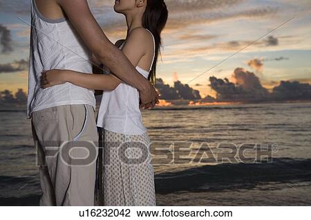 Young couple embracing on beach, Saipan, USA View Large Photo Image Stock Image - Young couple embracing on beach, Saipan, USA . Fotosearch