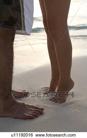 Young couple on beach, woman standing on toes, Saipan, USA View Large Photo Image Stock Photograph - Young couple on beach, woman standing on toes, Saipan, USA . Fotosearch