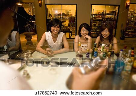 Stock Image - Young friends at a bar, Saipan. Fotosearch