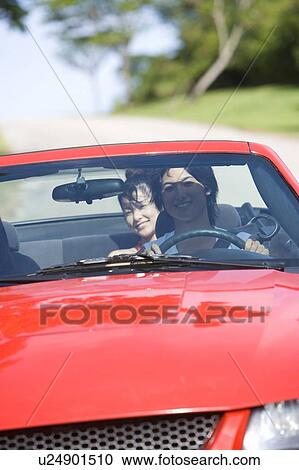 Stock Image - Young man and woman in the car, man driving, differential focus, Saipan, USA . Fotosearch