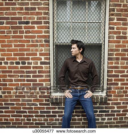 Asian man standing and leaning against window and brick wall. View Large Photo Image Stock Photo - Asian man standing and leaning against window and brick wall.. Fotosearch