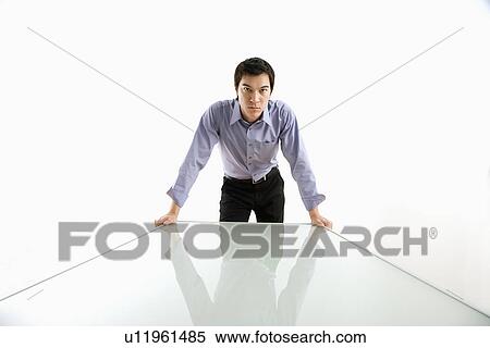Business man standing over conference table View Large Photo Image Stock Photography - Business man standing over conference table. Fotosearch