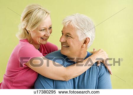 Couple in front of green wall hugging View Large Photo Image Stock Photography - Couple in front of green wall hugging. Fotosearch