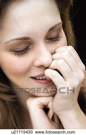 Stock Image - Female with hand on face. Fotosearch