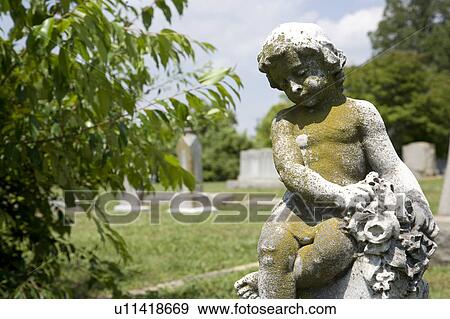 Stock Photo - Graveyard scene with cherub statue. Fotosearch