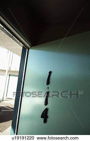 Stock Image - Green motel room door on ground floor that is wide open.. Fotosearch