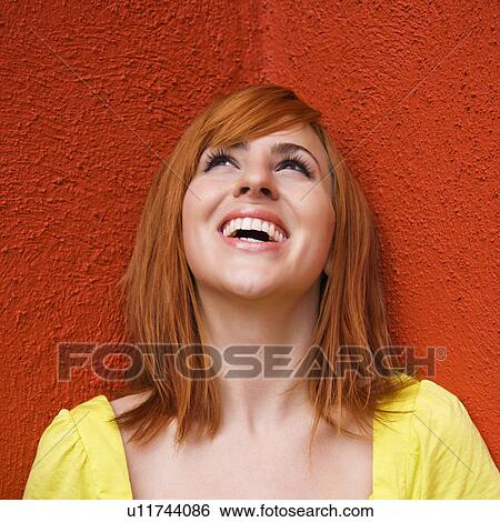 Stock Photograph - Portrait of smiling and laughing redhead looking up. Fotosearch