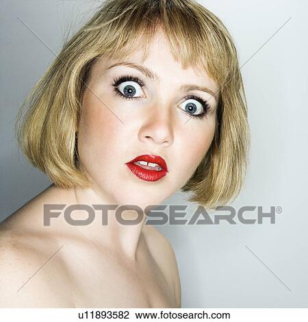 Stock Image - Portrait of young blonde woman who is looking at the viewer with confused expression. Fotosearch
