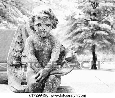 Stock Image - Statue in graveyard of cherub. Fotosearch