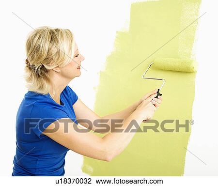 Woman painting wall green with paint roller View Large Photo Image Stock Image - Woman painting wall green with paint roller. Fotosearch